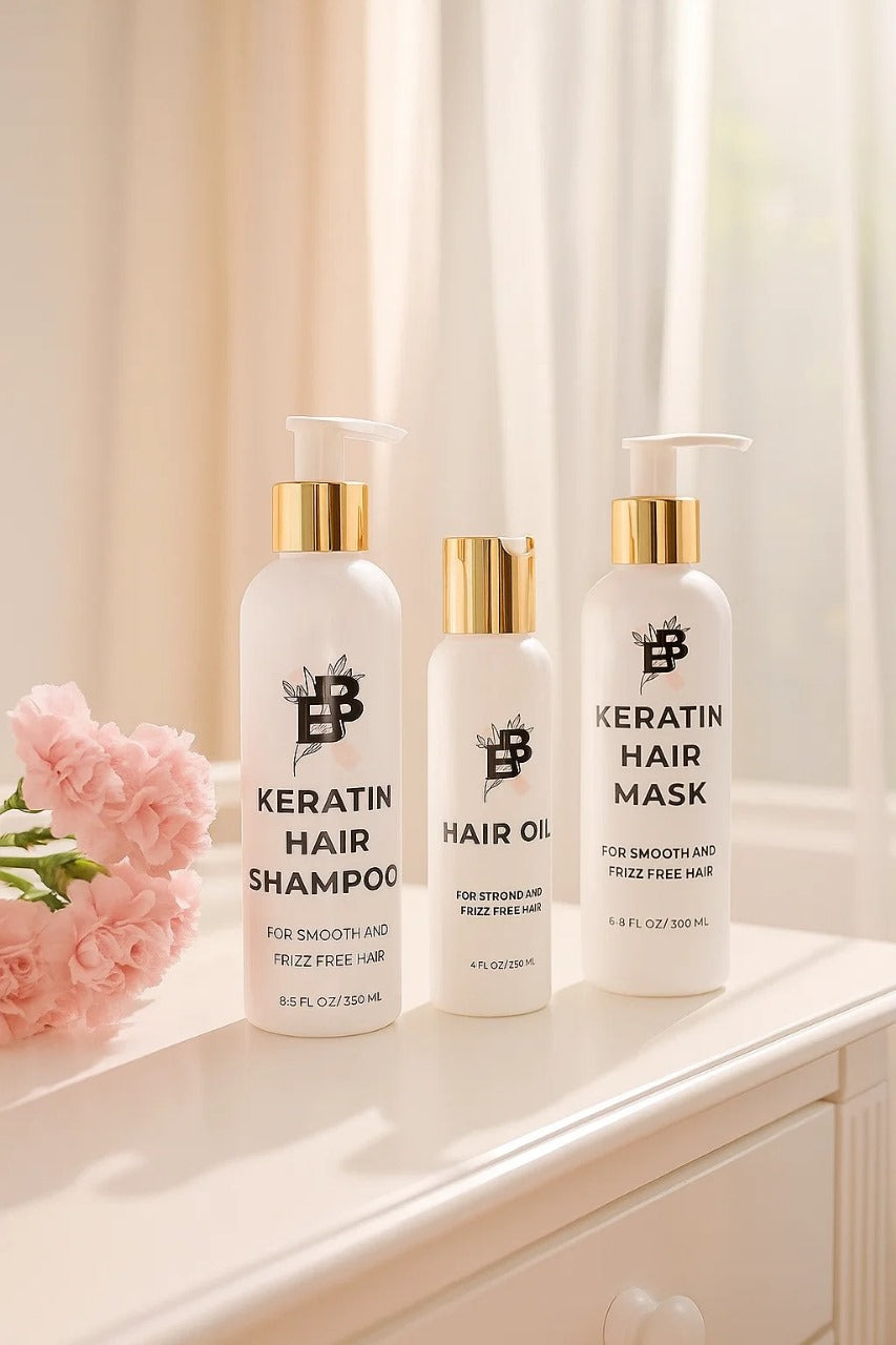 Three bottles of BBP Keratin hair care products on a white surface with pink flowers.